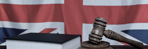 A UK flag in the background and a law books and judged gavel symbolising consumer law