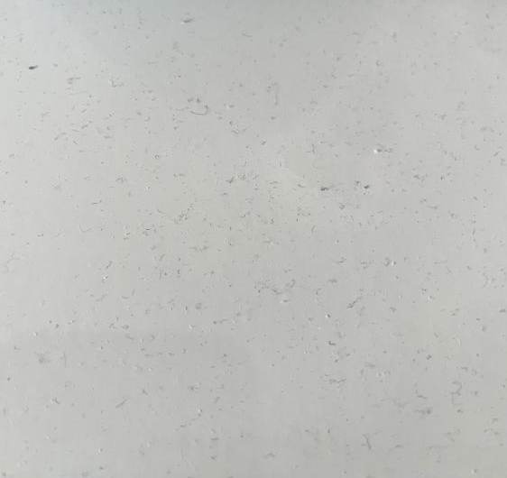 Hundreds of small fibres from a t-shirt settled on white bedside table top